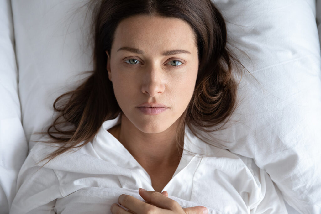 Depressed young woman rest in bed suffering from depression