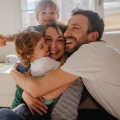 Image of a happy family embracing each other, highlighting Thai massage benefits, including enhanced emotional balance, stress relief, and improved mental well-being for a harmonious lifestyle.