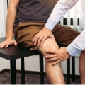 Image of a therapist examining a patient's knee, highlighting Thai massage benefits, including relief from knee arthritis pain and improved joint mobility for enhanced quality of life.